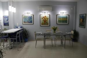 斯巴达Laconian Collection "Lykourgou 10"的一间带桌椅和绘画的用餐室