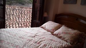 阿尔巴拉辛CASA CENTRO ALBARRACIN的一张带白色毯子和窗户的床