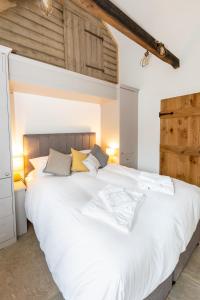 Great StukeleyThe Yard @ Pringle Farm的卧室设有一张白色大床,拥有木制天花板