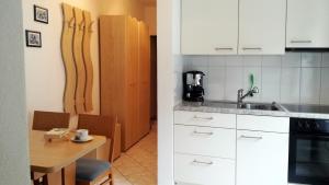 ContraCasa Meister的厨房配有白色橱柜和木桌