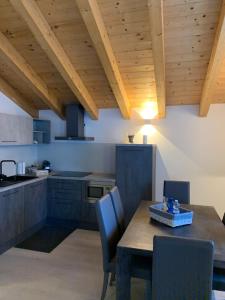 泰穆Alpin Sky的厨房设有木制天花板和桌椅