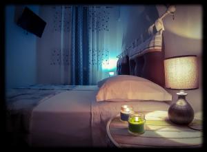 蓬扎La casa dei 4 venti的一间卧室配有一张带灯和两张蜡烛的床。
