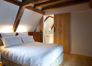 斯特拉斯堡Hotel Les Haras的卧室配有带木梁的白色床