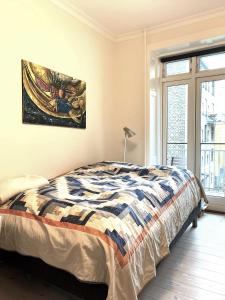哥本哈根ApartmentInCopenhagen Apartment 1436的卧室配有一张床,墙上挂有绘画作品