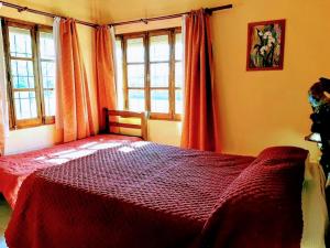 圣拉斐尔卡瓦尼亚斯卡尔德龙二号山林小屋的一间卧室设有红色的床和2个窗户