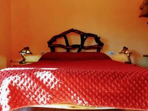 圣拉斐尔卡瓦尼亚斯卡尔德龙二号山林小屋的一间卧室配有一张红色的床,上面有两盏灯