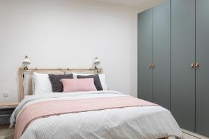 MġarrCosy apartment in Historic Fort Chambray, Gozo的一间卧室配有一张带粉红色枕头的床