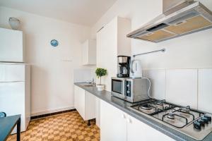 安特卫普Lucky Lambert Apartment的厨房配有白色橱柜和炉灶烤箱。