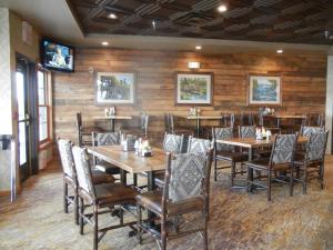 ElyGrand Ely Lodge的餐厅拥有木墙和桌椅