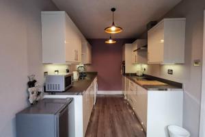 格拉斯哥Broomfield Cottage South Luss的厨房配有白色橱柜和微波炉
