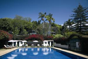 丰沙尔库恩塔卡萨布昂卡酒店的一个带椅子和遮阳伞及树木的游泳池