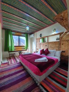 伊姆利尔Riad Atlas Imlil的一间设有一张大床的卧室,位于带绿色天花板的房间内