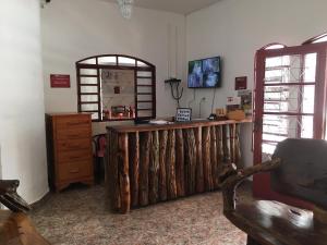 皮雷诺波利斯Pousada Pollyana的客房设有木制柜台、椅子和窗户。