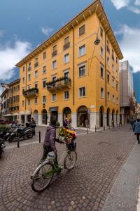 维罗纳Corte Melone room rental的骑着自行车在黄色建筑前的人