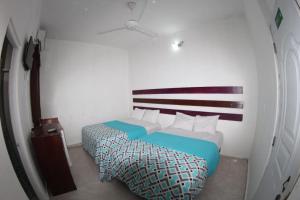 圣多明各Caribbean Hotel Santo Domingo的一间小房间,房间内设有两张床