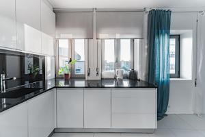 加亚新城ANITAHOUSE的厨房配有白色橱柜和蓝色窗帘