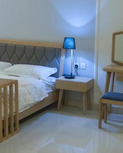 阿尔卡吉Vivian Park Chalets的一间卧室配有一张带一张蓝色台灯的桌子