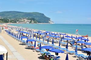 努马纳加拉斯酒店的海滩上设有蓝色的遮阳伞和椅子,还有海洋