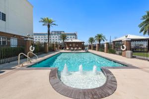 圣安东尼奥圣安东尼奥北部石橡树区烛木套房酒店的一座建筑中间的游泳池,带喷泉