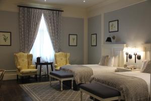 瓜亚基尔帕克酒店的一间卧室设有两张床、一张桌子和一个窗口