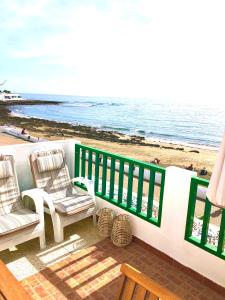 宏达海滩Luxury Suite Sea Front的阳台配有两把椅子,享有海滩美景