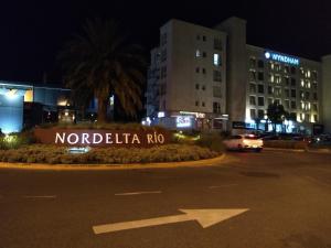 蒂格雷Departamentos Condominio Wyndham Nordelta - Desayuno y Spa Opcional !的一个晚上在停车场里说诺迪卡罗的标志