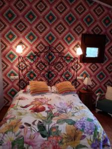 阿雷纳斯德圣佩德罗Hotel Rural El Marquesito Antigua Casa Carmela的一间卧室配有一张带图案墙壁的床