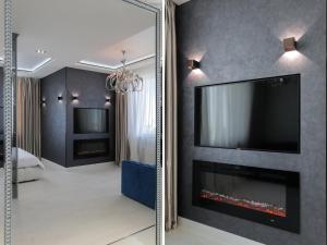基辅White Tiger Apartment in Smart Plaza的客房内的镜子配有电视和壁炉