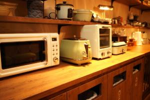 箱根Onsen Guest House Tsutaya的厨房柜台配有微波炉和其他电器