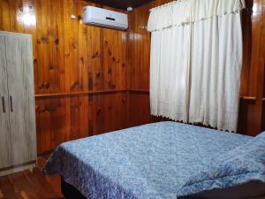 特雷齐蒂利亚斯Casa de Ferias Dona Inês的一间卧室配有一张带蓝色毯子的床和窗户。