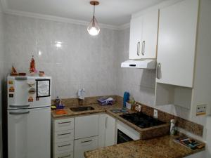 伯迪亚哥Ed.fragatas residence的厨房配有白色橱柜和白色冰箱。