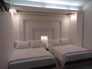 圣罗莎德卡瓦尔CIELITO LINDO的白色客房的两张床,光线充足