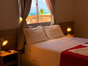 马拉戈日Pousada Paraíso Maragogi的一间卧室配有一张床,享有海滩美景