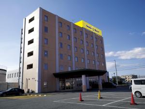 YoshidaSmile Hotel Shizuoka Yoshida Inter的酒店大楼前面设有停车场