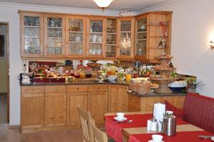 魏森湖霍斯比特酒店的厨房配有木制橱柜和桌椅