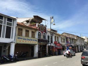 马六甲Thian Siong Inn的街道上拥有建筑和汽车的城市街道