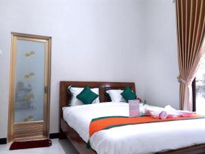 PurbolinggoHomestay Purbalingga Tengah Kota by Simply Homy的一间卧室设有一张床和一个窗口