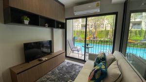 华欣La Casita pool access condo HuaHin的带沙发和平面电视的客厅