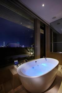台北天阁酒店台北长安的窗户客房内的白色浴缸