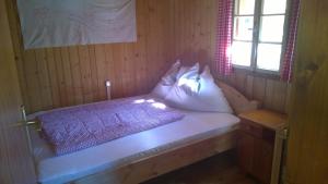 海利根布卢特Ferienhütte Ortnerkasa的客房配有带枕头的床和窗户。