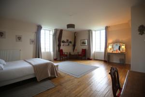 Saint-Germain-le-Guillaume拉斯科里住宿加早餐旅馆的卧室配有一张床和一张桌子及椅子