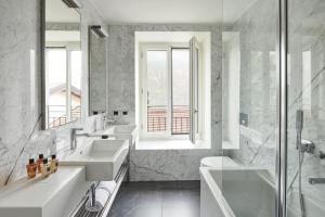 贝拉吉奥贝维德雷酒店的白色的浴室设有2个盥洗盆和淋浴。