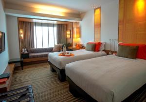 清迈dusitD2 Chiang Mai的酒店客房,设有两张床和一张沙发