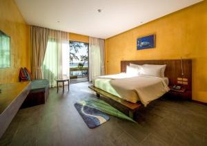 迈考海滩Coriacea Beachfront Boutique Phuket Resort - SHA Plus的一间卧室设有一张大床和一个大窗户