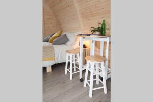 布莱尔高里Isla Pod, Kilry eco pods的配有一张床、一张桌子和凳子的房间