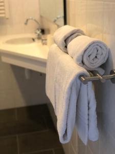 斯希蒙尼克奥赫Strandhotel Om de Noord, logies en ontbijt的浴室提供毛巾架上的毛巾