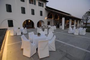 Ceggia卡萨代坎特伯雷乡村民宿的一组白色的桌椅,位于一座建筑前