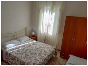 蓬扎La casa dei 4 venti的一间卧室配有一张床、一个梳妆台和一扇窗户。