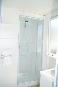 加桑Camping Montana Parc - Gassin Golfe de St Tropez - Maeva的白色的浴室设有玻璃门淋浴