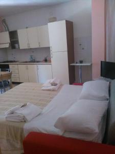 波利卡斯特罗巴森迪诺Appartamenti Centro Policastro的一间卧室配有一张大床,上面有白色毛巾